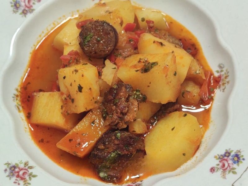 Krompir paprikaš u belom tanjiru sa kobasicom