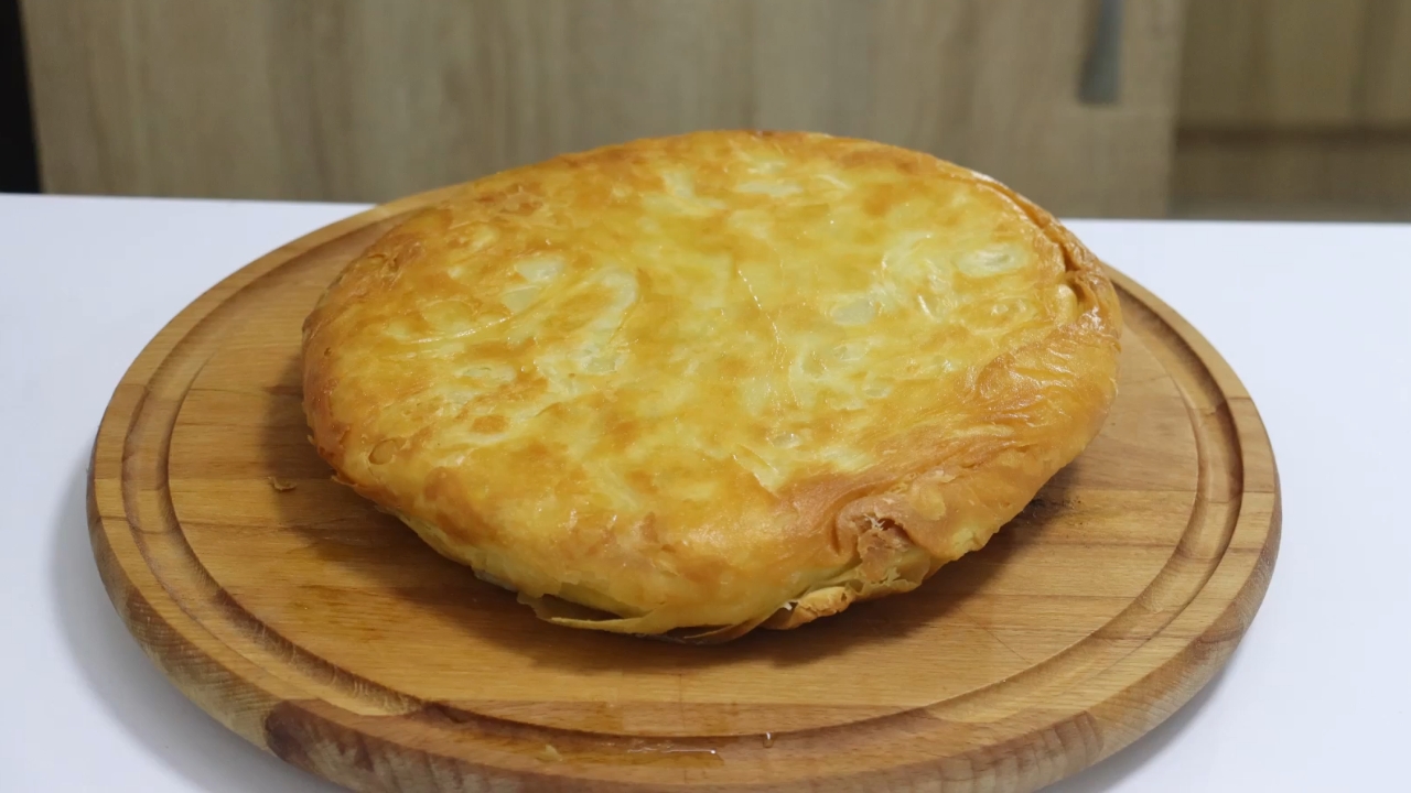 Zlatno pečen nišlijski burek poslužen na drvenoj dasci