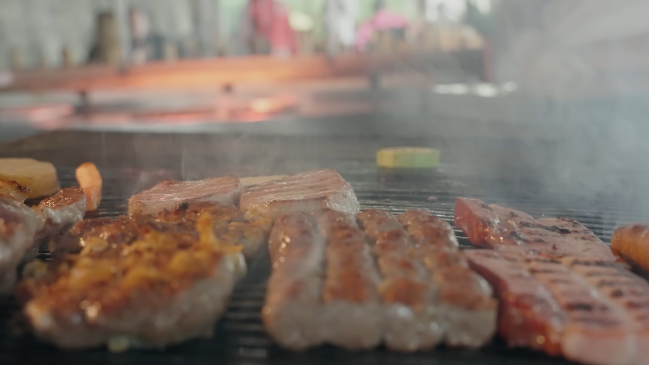 Meso i kobasice peku se na roštilju uz dim sa žara