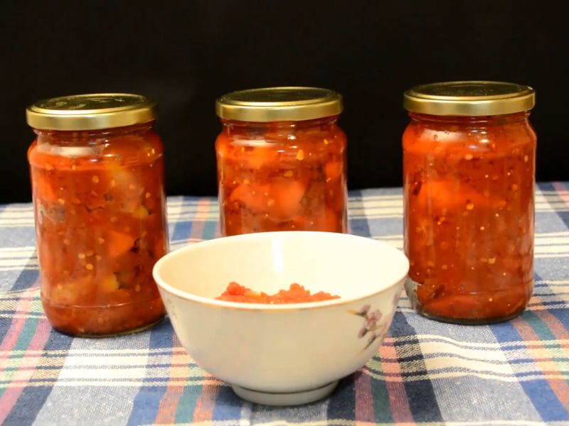 tri tegle ljutenice poređane na stolu sa belom činijom u kojoj je takođe ljutenica